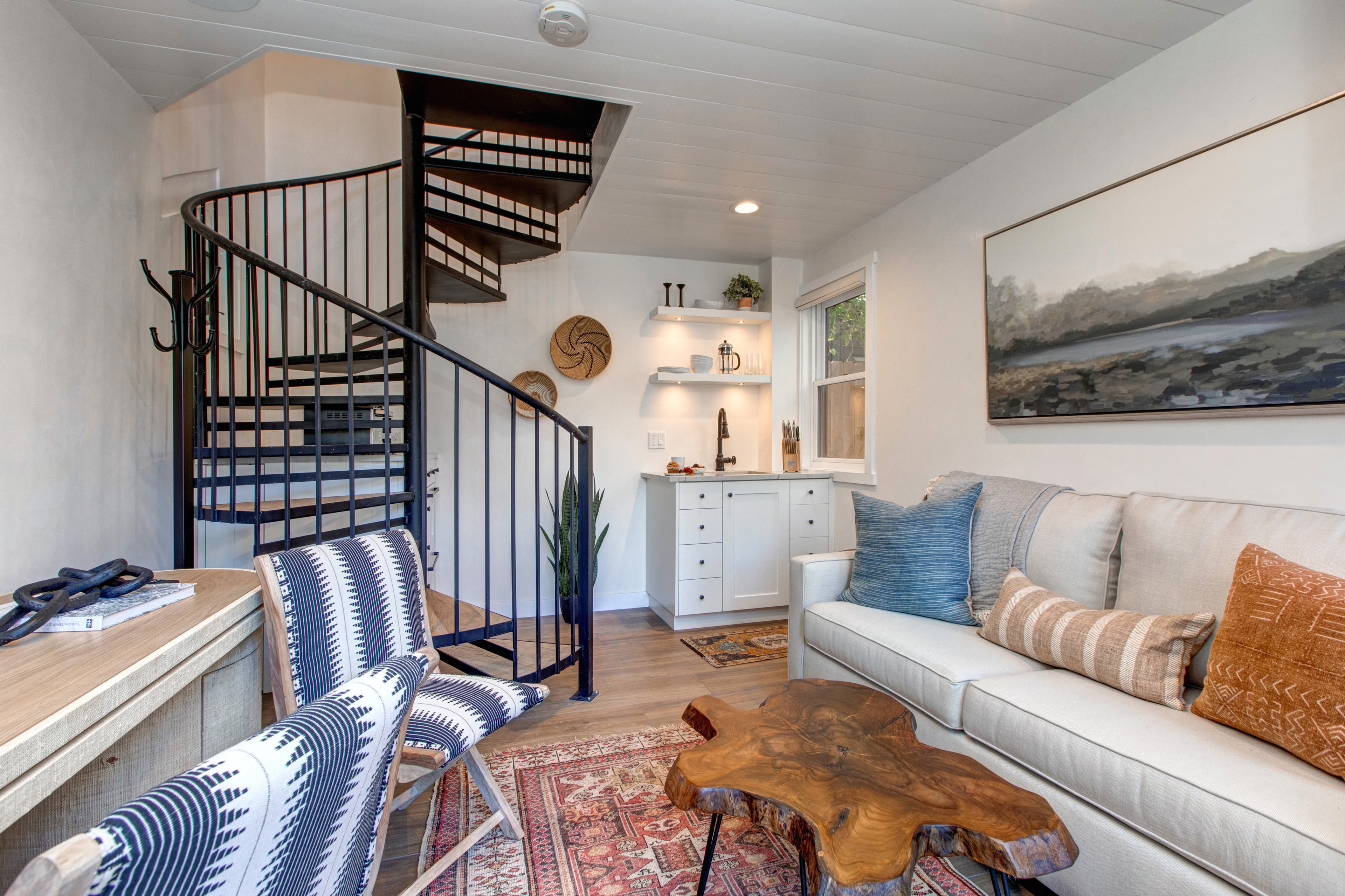 Detached guest suite accessed via the patio. Features a living area with a small kitchenette, TV, a desk and a queen sleeper sofa for additional guests.