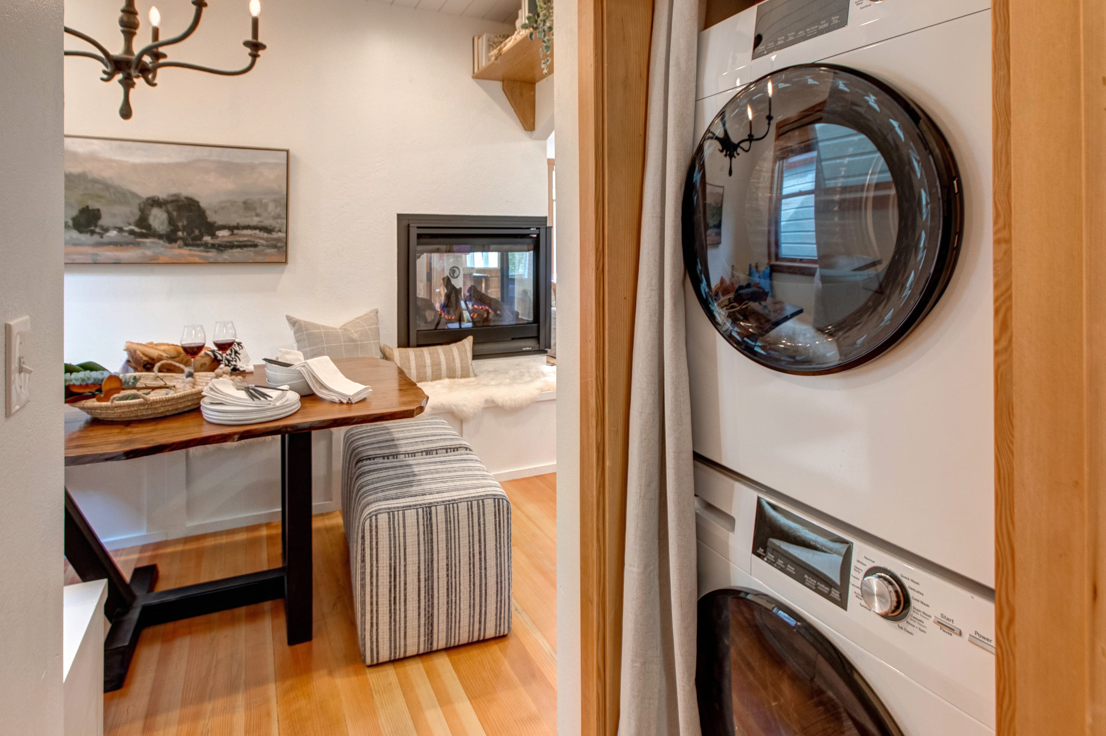 Stacked laundry and dryer next to dining area.