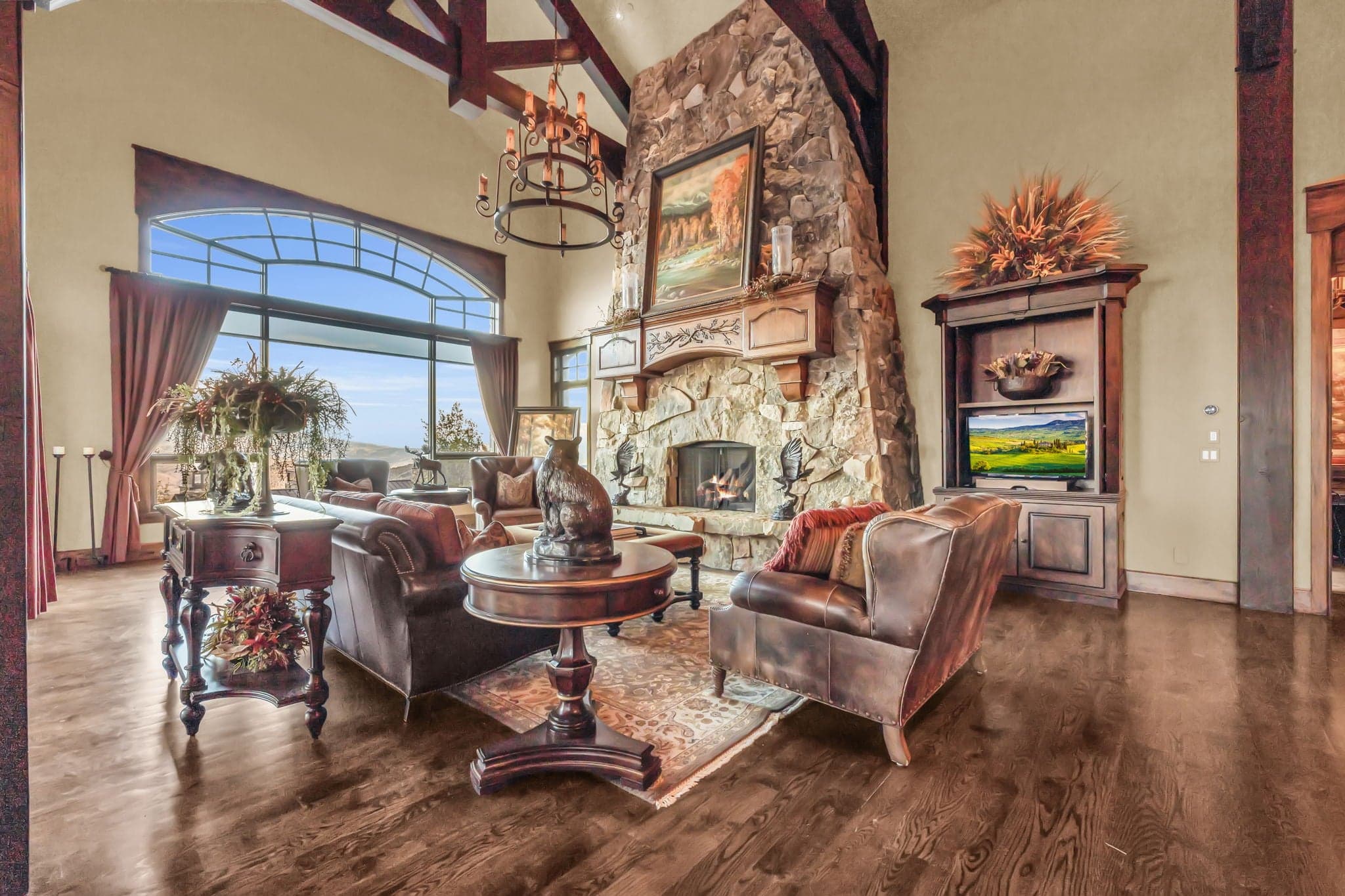 Grand fireplace with paintings and leather couches.
